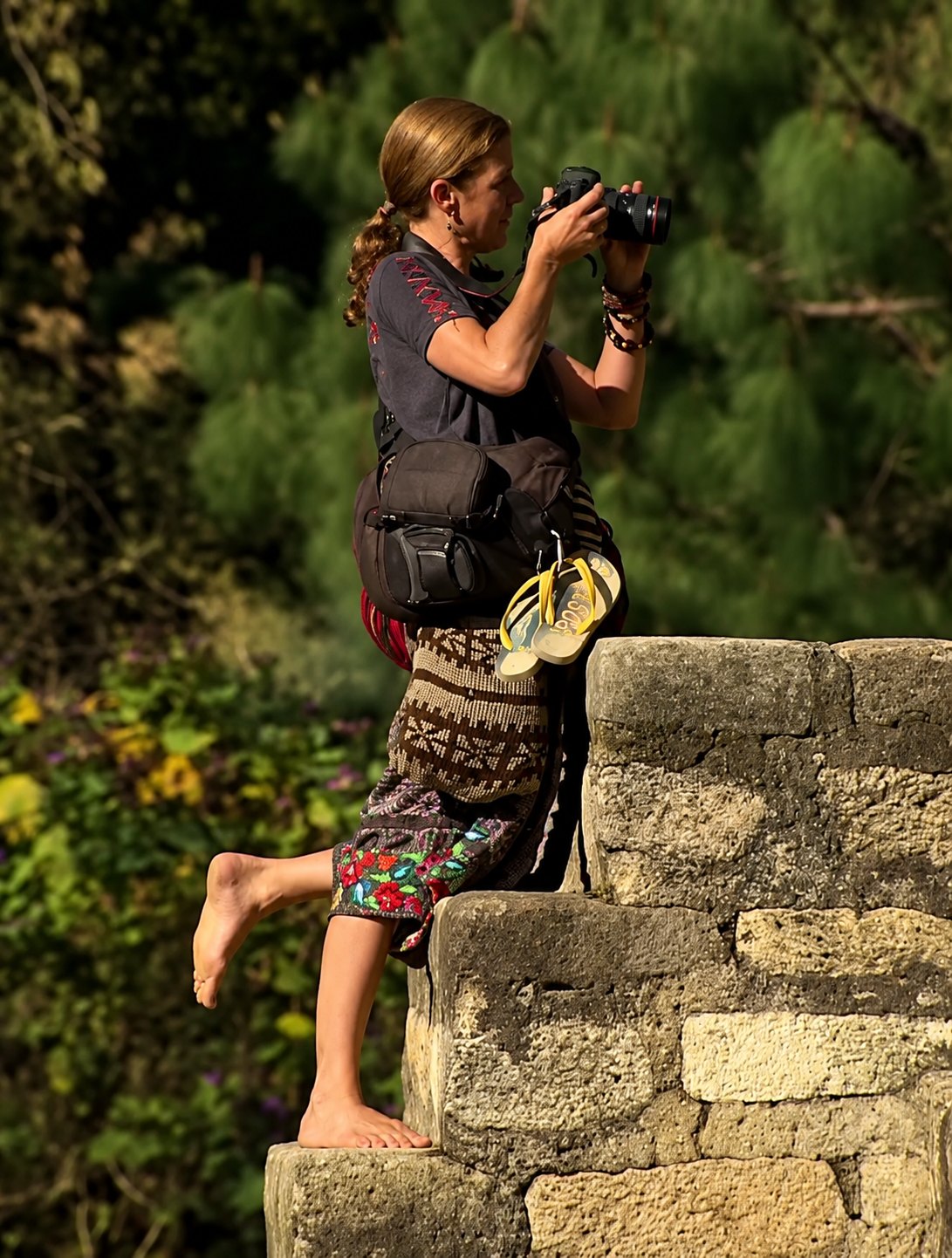 Gg with a camera on a stone wall in Guatemala